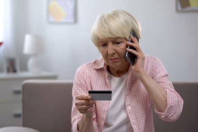 mature woman on phone with card